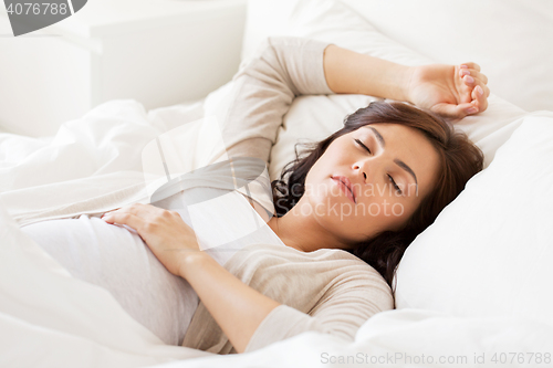 Image of happy pregnant woman sleeping in bed at home