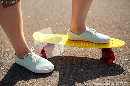 Image of close up of female feet riding short skateboard