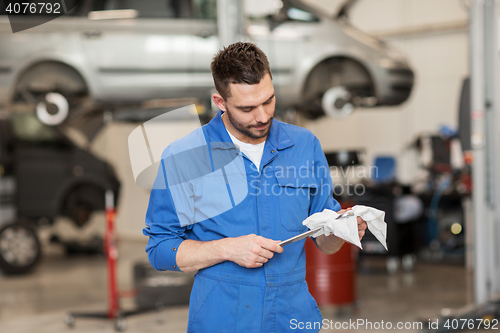 Image of auto mechanic or smith with wrench at car workshop