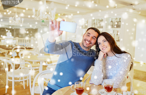 Image of couple taking smartphone selfie at cafe restaurant