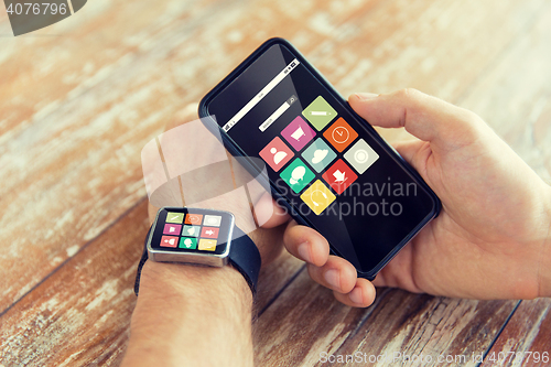 Image of close up of hands with smart phone and watch