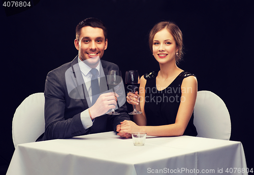 Image of young couple with glasses of wine at restaurant