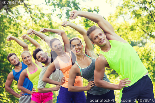 Image of group of friends or sportsmen exercising outdoors