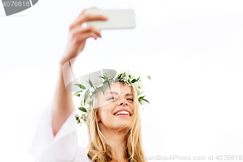 Image of happy young woman taking smartphone selfie