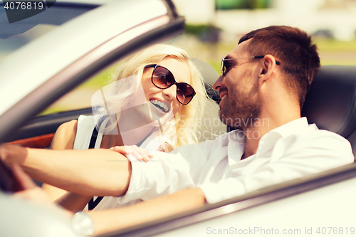 Image of happy man and woman driving in cabriolet car