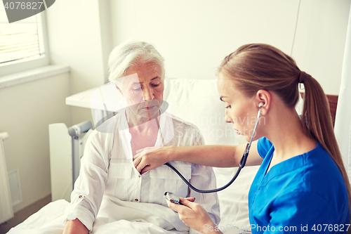 Image of nurse with stethoscope and senior woman at clinic