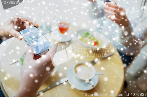 Image of close up of couple picturing food by smartphone