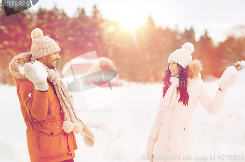 Image of happy couple playing snowballs in winter