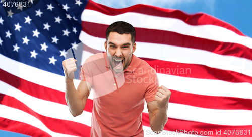 Image of angry man showing fists over american flag