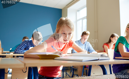 Image of student girl with book writing school test