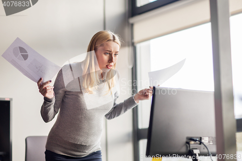 Image of pregnant businesswoman stressing at office work