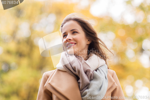 Image of beautiful happy young woman smiling in autumn park