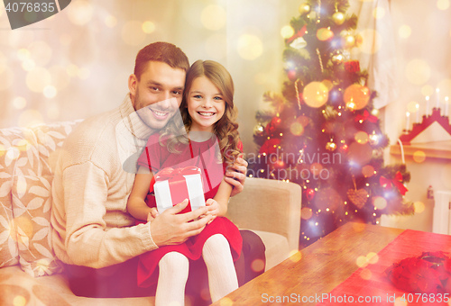 Image of smiling father and daughter holding gift box