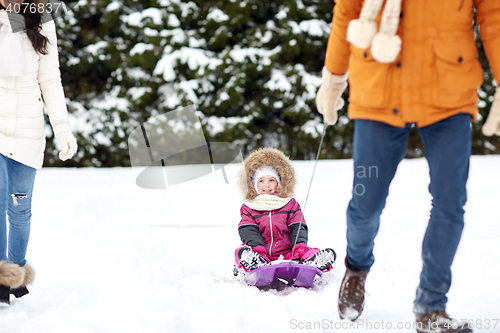 Image of happy family with sled walking in winter forest