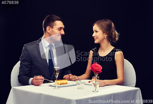 Image of smiling couple eating dessert at restaurant