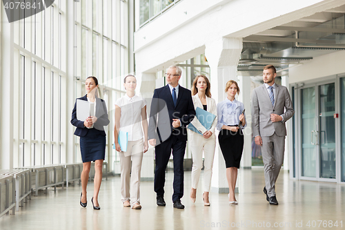 Image of business people walking along office building