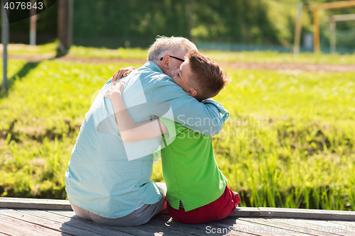 Image of grandfather and grandson hugging on berth