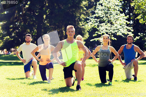 Image of group of friends or sportsmen exercising outdoors