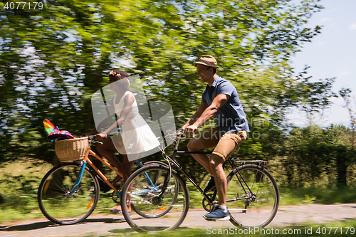 Image of Young multiethnic couple having a bike ride in nature