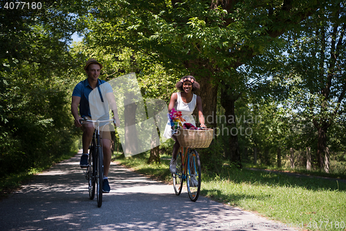 Image of Young multiethnic couple having a bike ride in nature