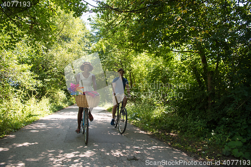 Image of Young multiethnic couple having a bike ride in nature