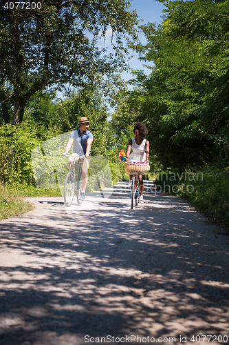 Image of Young multiethnic couple having a bike ride in nature