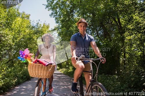 Image of Young multiethnic couple having a bike ride in nature