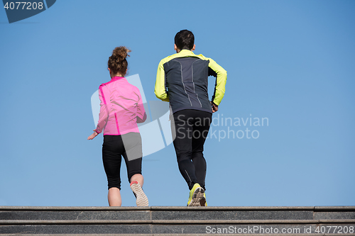 Image of young  couple jogging on steps