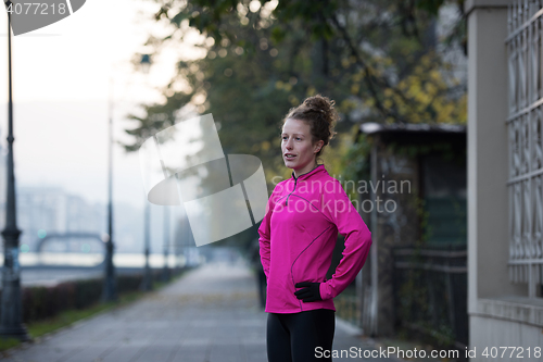 Image of woman  stretching before morning jogging