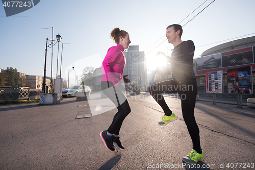 Image of couple warming up before jogging