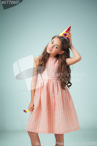 Image of The cute cheerful little girl with festive cap on gray background