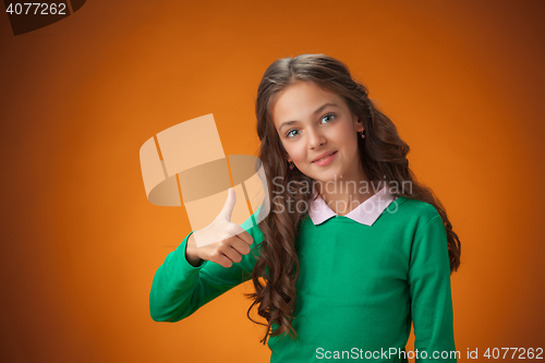 Image of The cute cheerful little girl on orange background