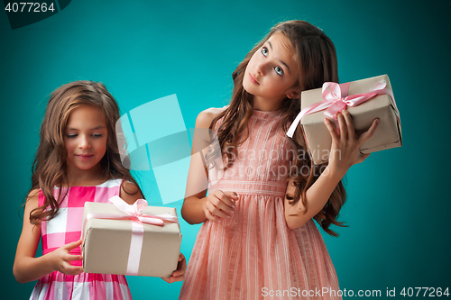 Image of The two cute cheerful little girls on blue background