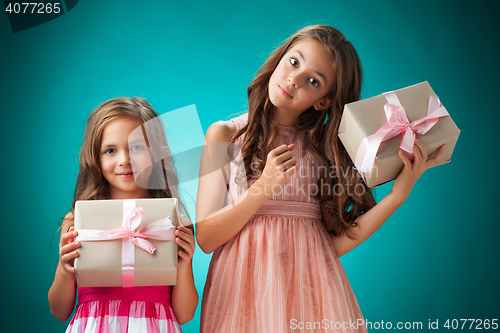 Image of The two cute cheerful little girls on blue background