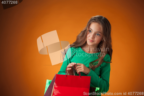 Image of The cute cheerful little girl with shopping bags