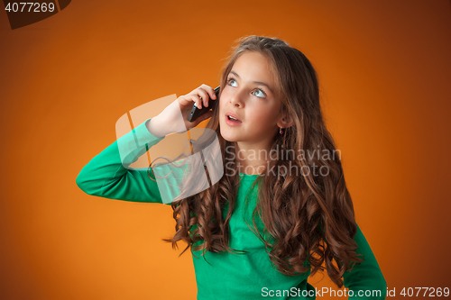 Image of The cute cheerful little girl on orange background