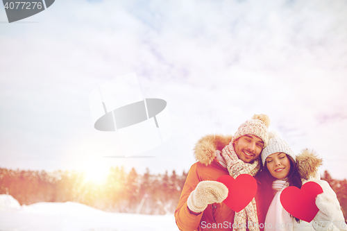 Image of happy couple with red hearts over winter landscape