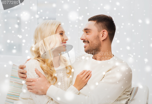 Image of happy couple hugging on sofa at home