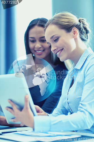 Image of smiling businesswomen with tablet pc in office