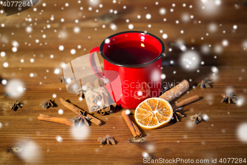 Image of close up of tea cup with spices on wooden table
