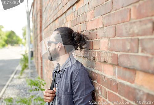 Image of man with backpack standing at city street wall