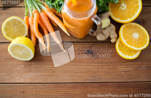 Image of glass jug of carrot juice, fruits and vegetables