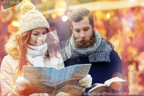 Image of happy couple with map and city guide in old town