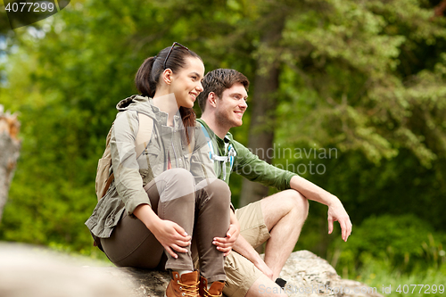 Image of smiling couple with backpacks in nature