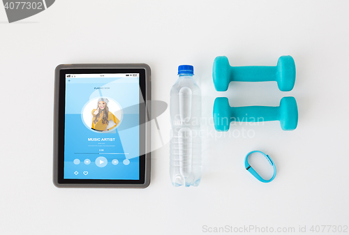 Image of tablet pc, dumbbells, fitness tracker and bottle
