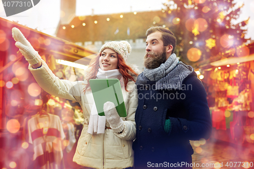 Image of happy couple walking with tablet pc in old town