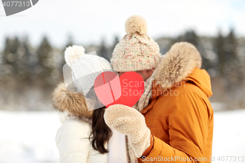 Image of happy couple with red heart over winter landscape