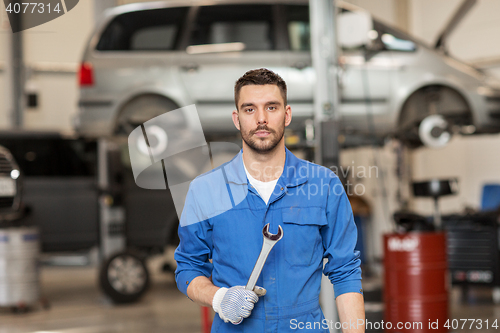 Image of auto mechanic or smith with wrench at car workshop