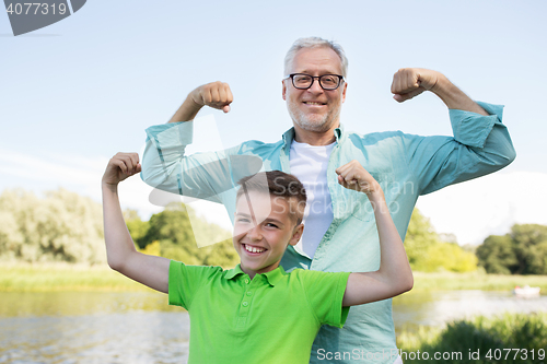 Image of happy grandfather and grandson showing muscles