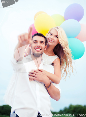 Image of couple with colorful balloons at sea side